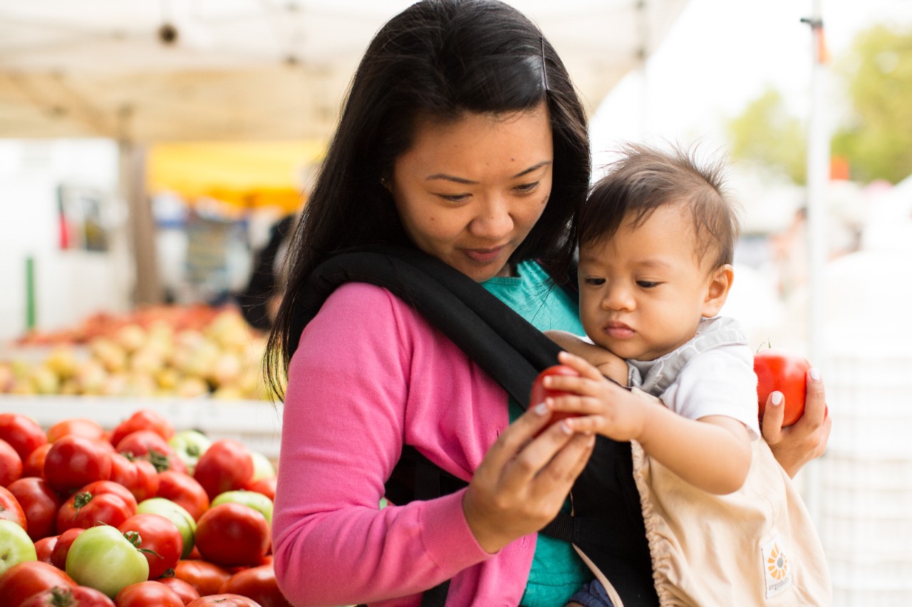 A woman and her baby at a farmers' market.