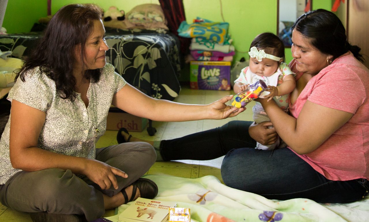 Two women caring for a infant at home.