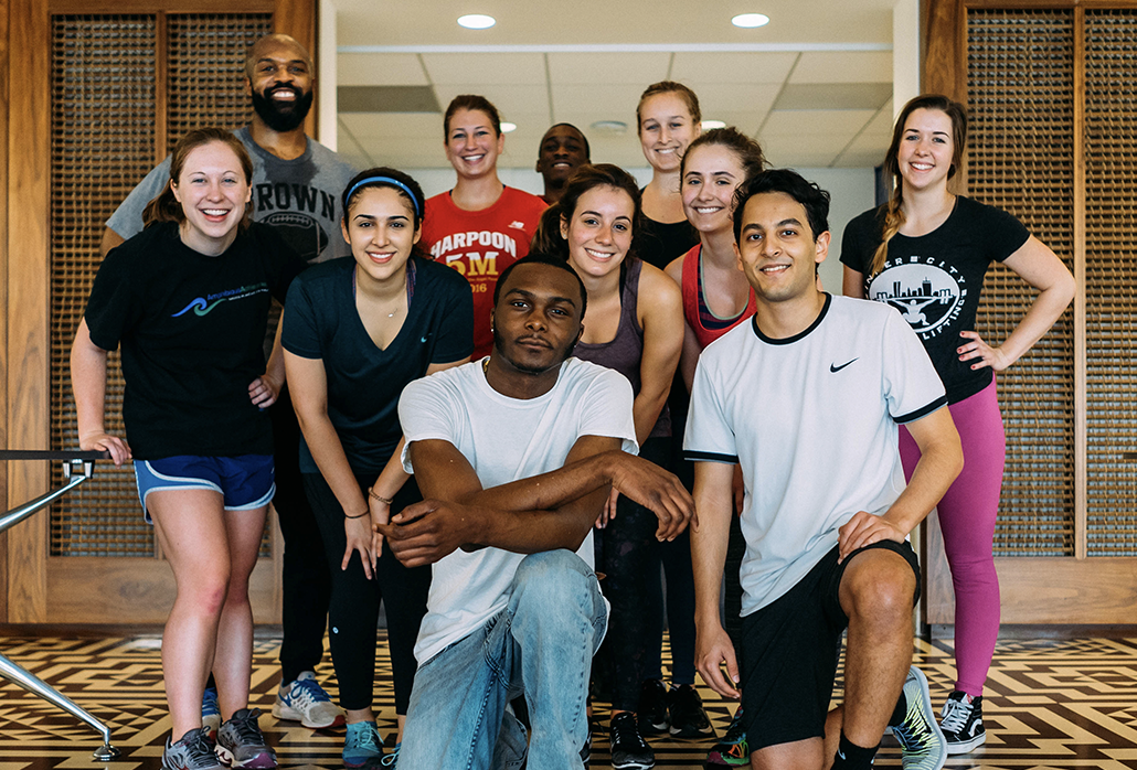 A diverse group of adults pose for a photo before exercising.