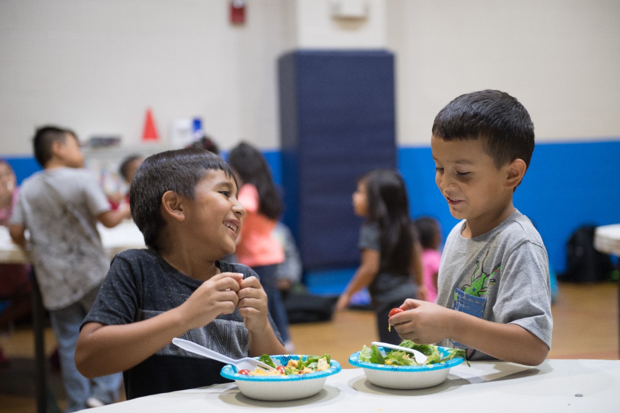 Kevin Rebolledo, left, 6, and Issac Mendez, 7, eat salads as a snack at YMCA Judson Community Center. The YMCA Judson Community Center is located in Sterling, which is one of Greenville's special emphasis neighborhoods.