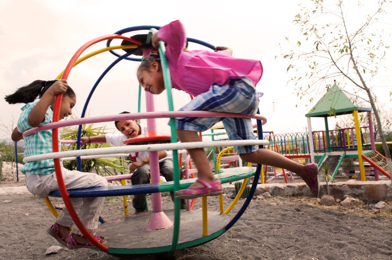 Three children playing at a playground..