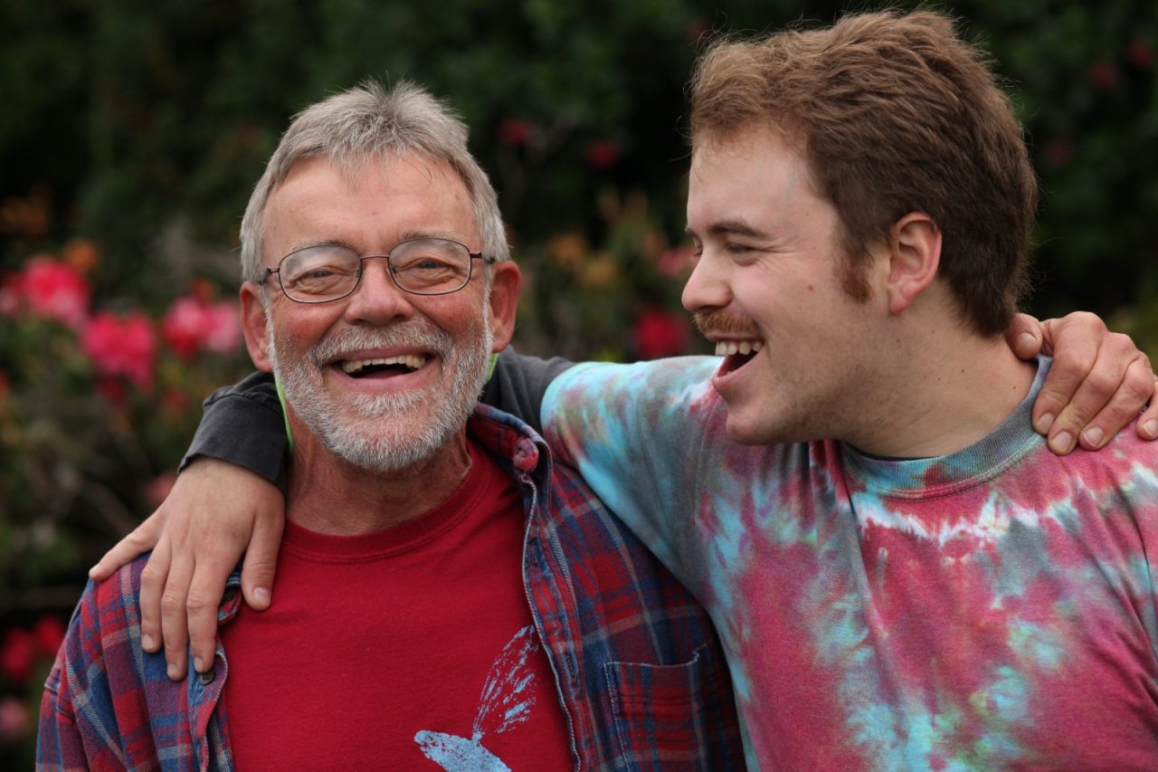 A happy father and son standing in a garden.