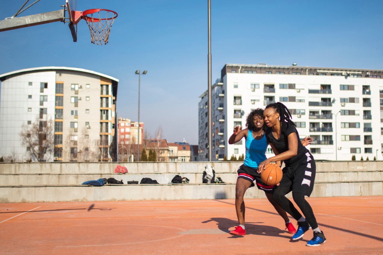 Two female african-american playing basketball