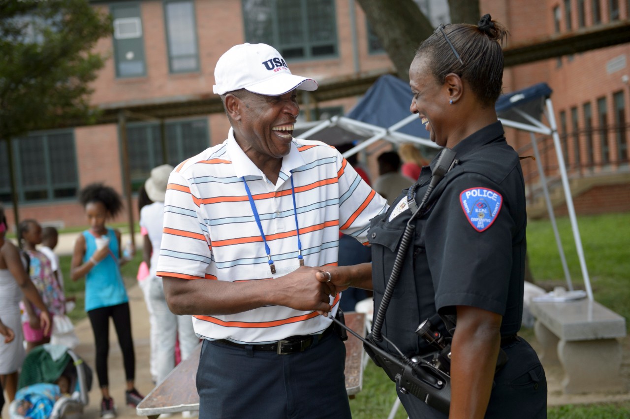 A man shaking hands with a police officer.