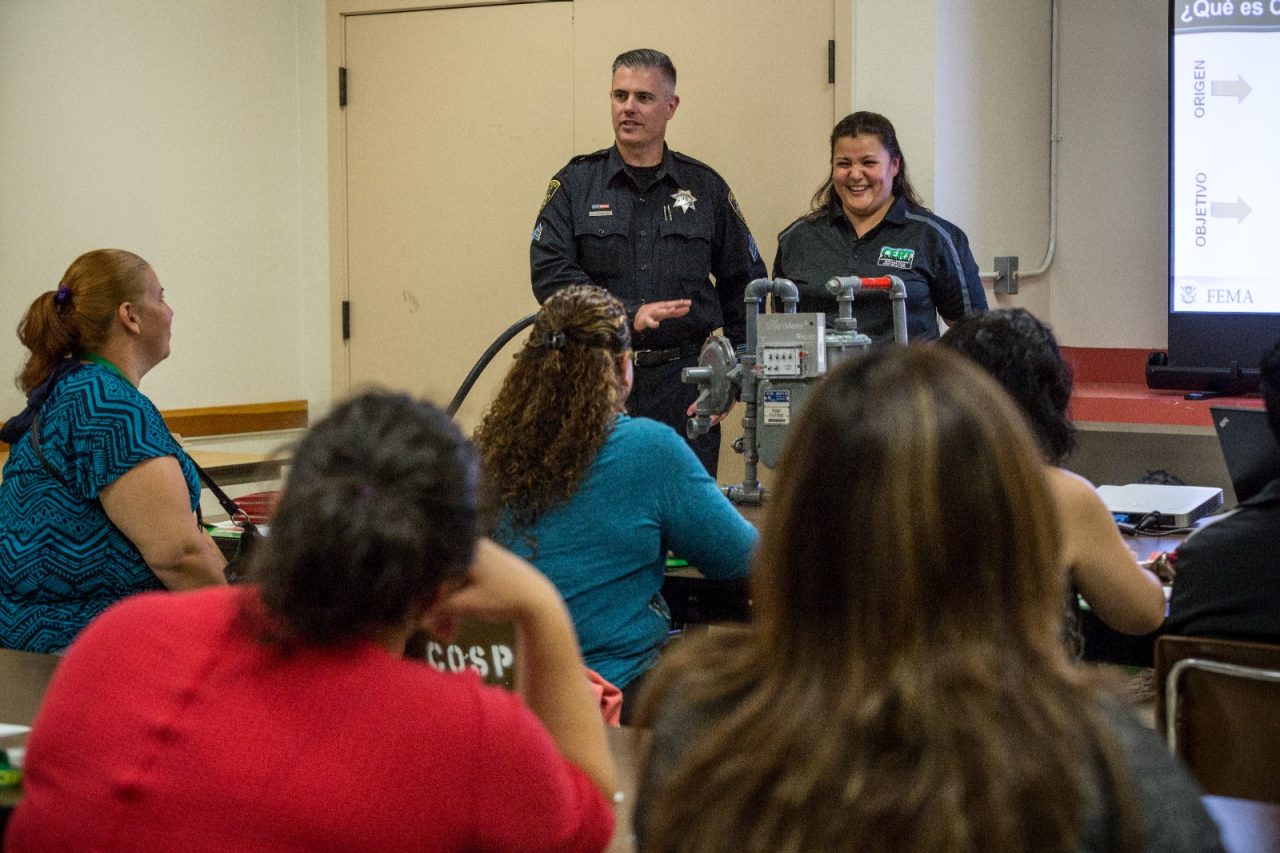 Sgt. Jeremy Johnson of the San Pablo Police Departmen and Alma Pelayo address the Spanish-language CERT (Community Emergency Response Team) class at Davis Park in San Pablo.CERT is a training program that gives individuals the basic disaster response skills to offer vital support to their family, associates and neighborhood while awaiting help from first responders. The course is offered once a week for 8 weeks with a final drill/graduation on a Saturday. San Pablo offers CERT training in both English and Spanish.
