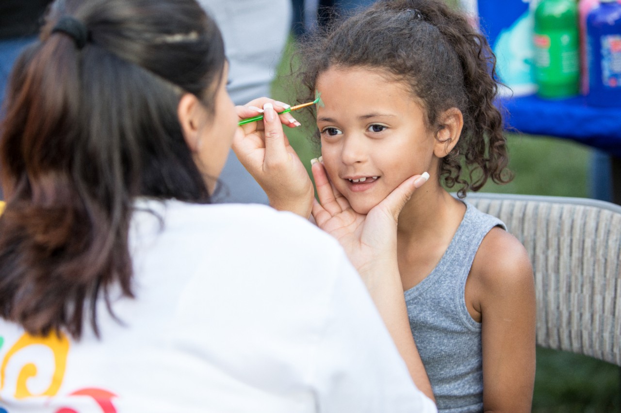 A young girl getting face painting.