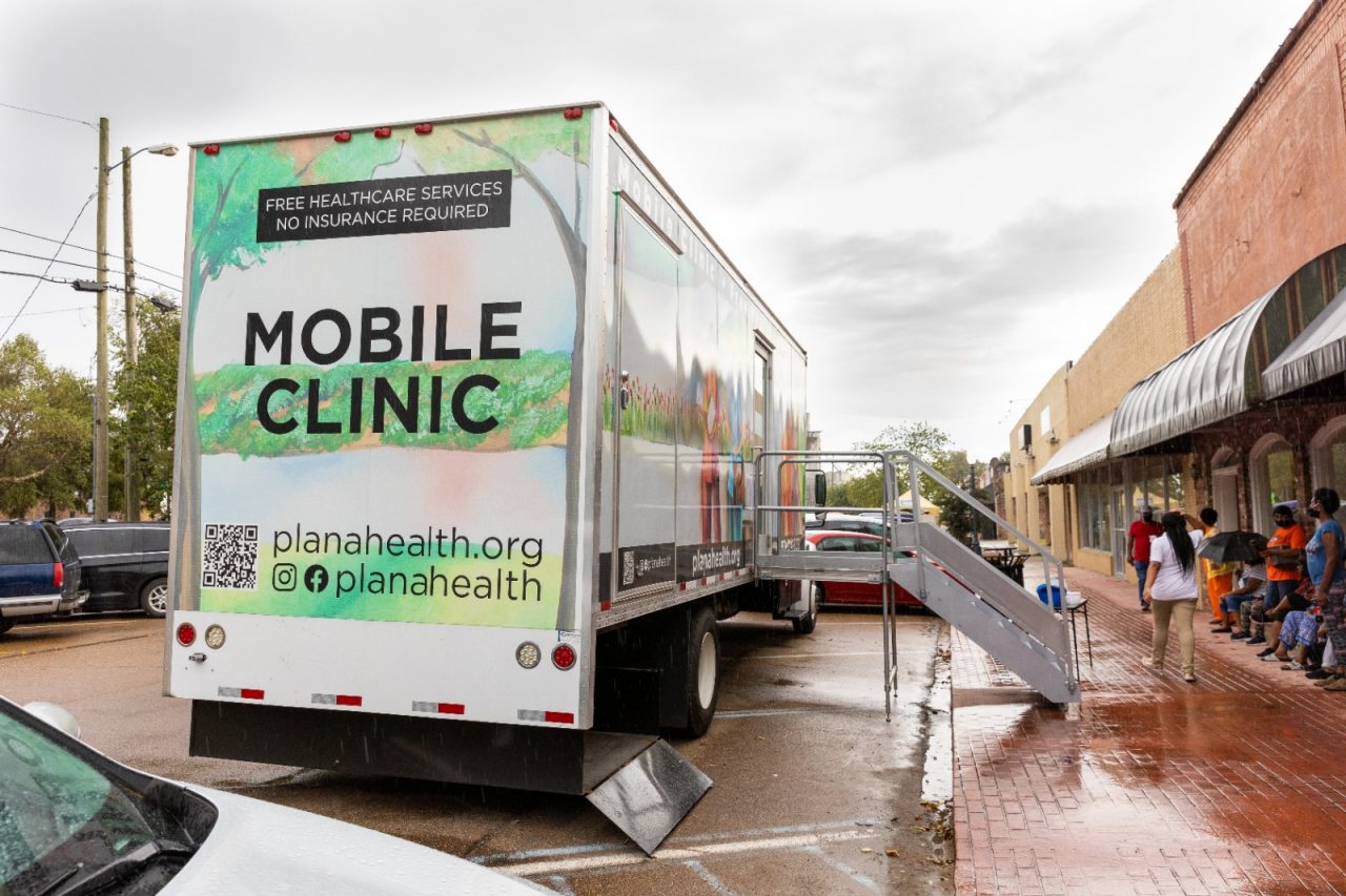 Residents line up outside of a mobile clinic.
