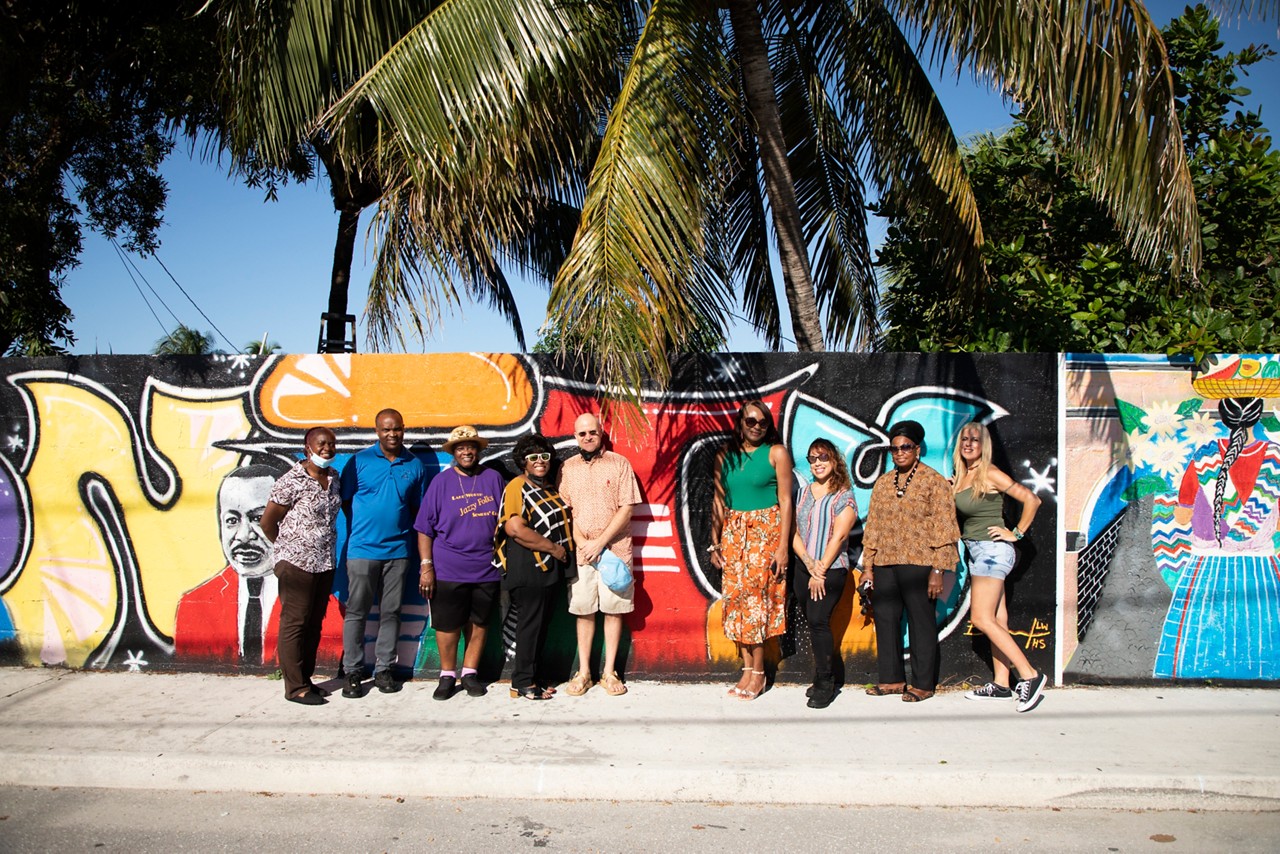 Pictured right to left as follows : Sandra Lula Gover, Roselyn Davis (brown shirt), Sidney Rodriguez, Carmelle Marcelin-Chapman (green top), Samuel Goodstein (bald man), Carla Blockson (sunglasses with black, white and brown top), Retha Lowe (purple shirt), Patrick Livingston (blue shirt) and Adella Bell (very left of frame) at the Unity Wall. A wall that formerly served as a symbol of division is now a beacon of light for inclusion and diversity in Lake Worth Beach. The wall served as an unofficial border between the residents of the "Osborne Colored Addition" and their white neighbors. The city's zoning code required Black residents to live in the Osborne subdivision until 1969. 67 South Florida professional artists and residents helped paint the 1,175 foot long wall with art murals that represent the past, present, and future of the community.