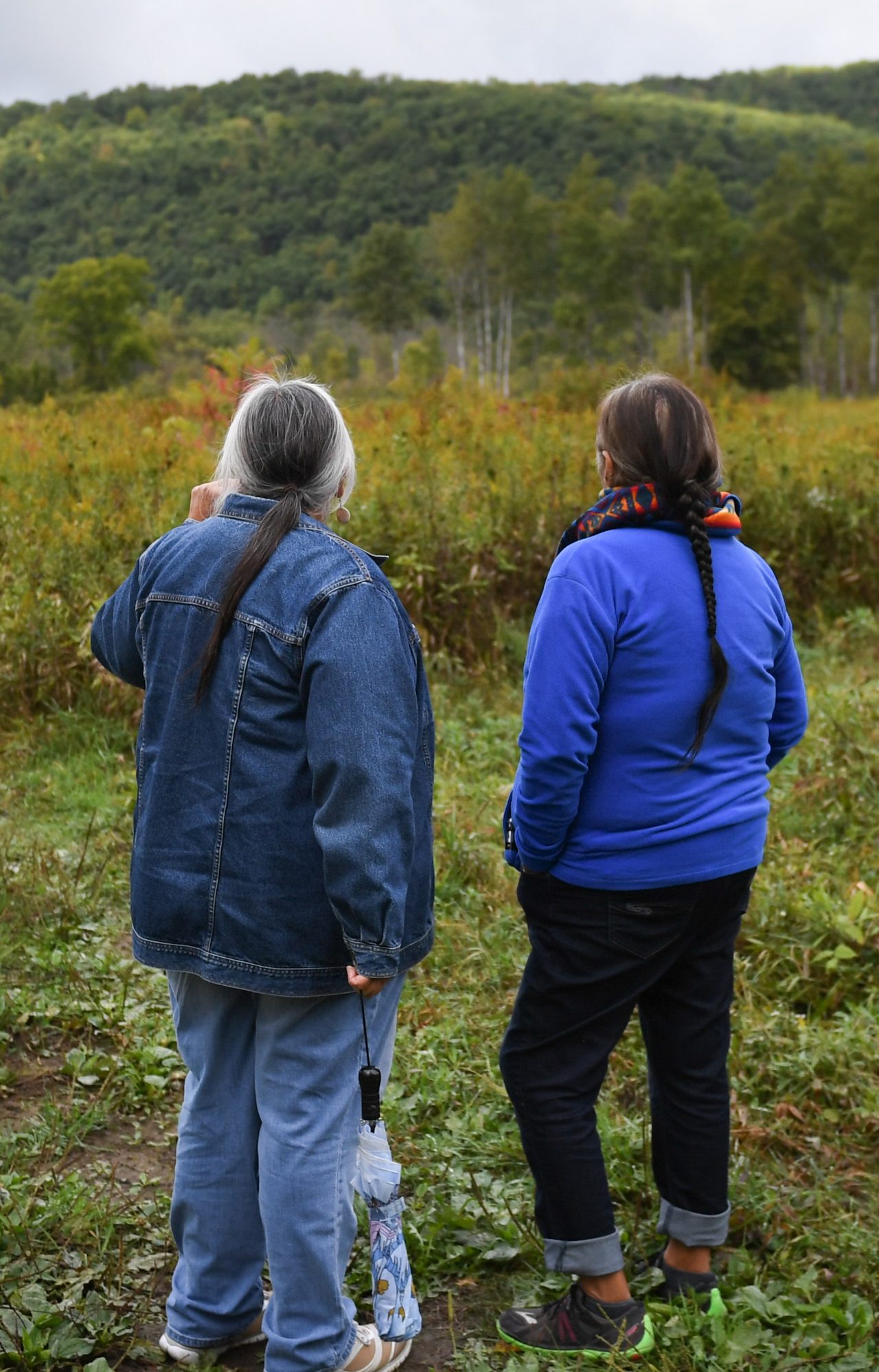Two women standing in a field.