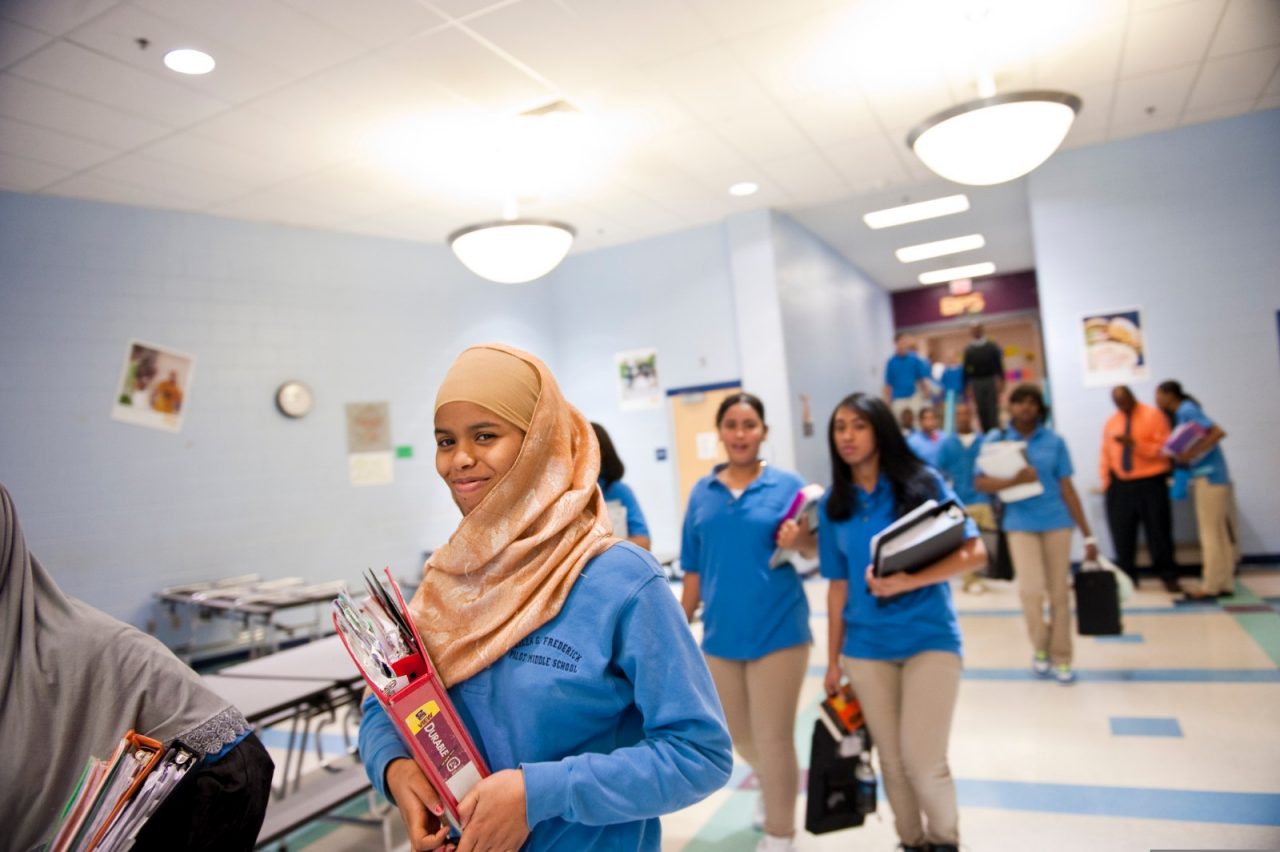 High school students walking through a school corridor.