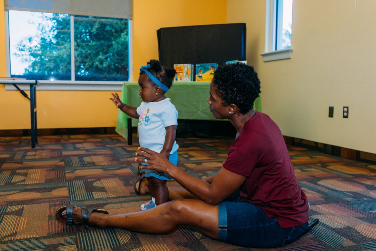 A mother and toddler attending a workshop at a library.