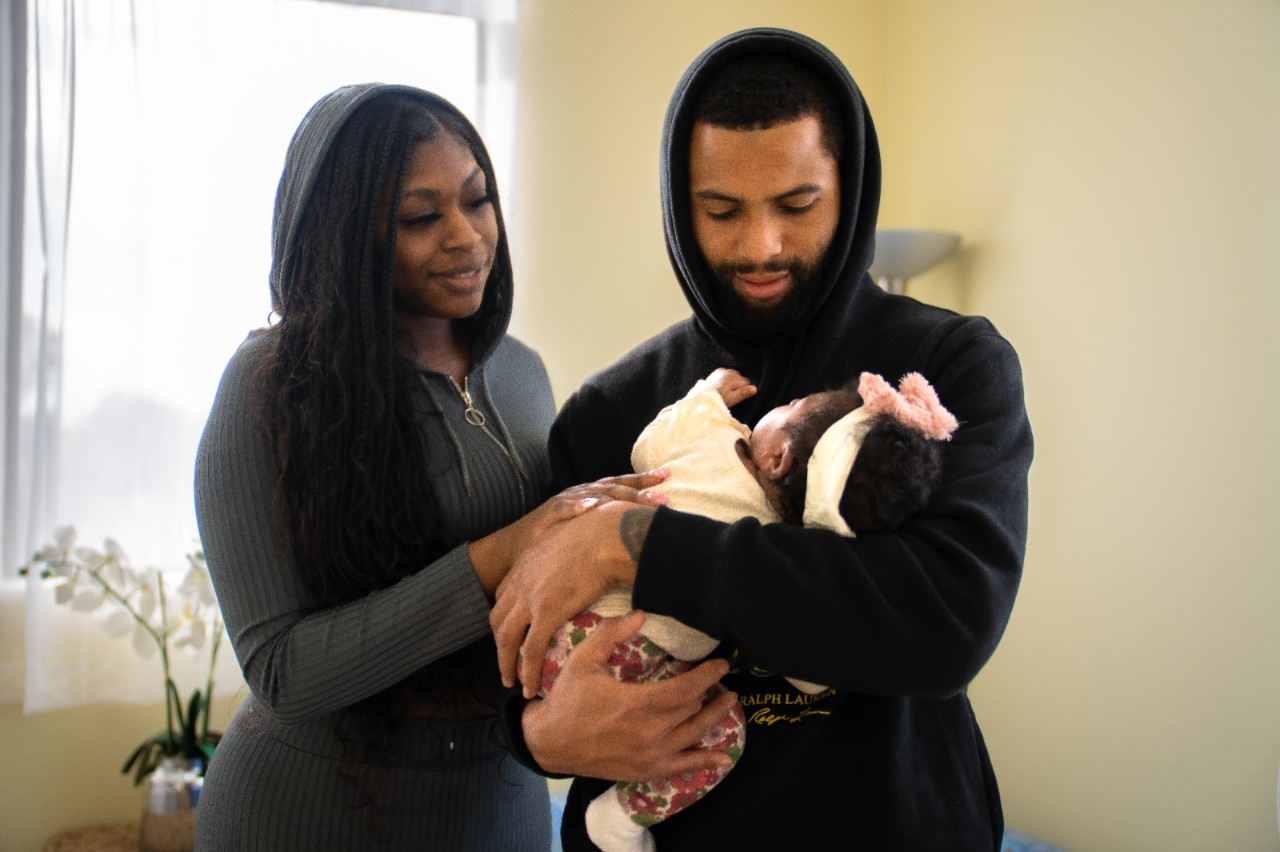 Parents look adoringly at their newborn child.