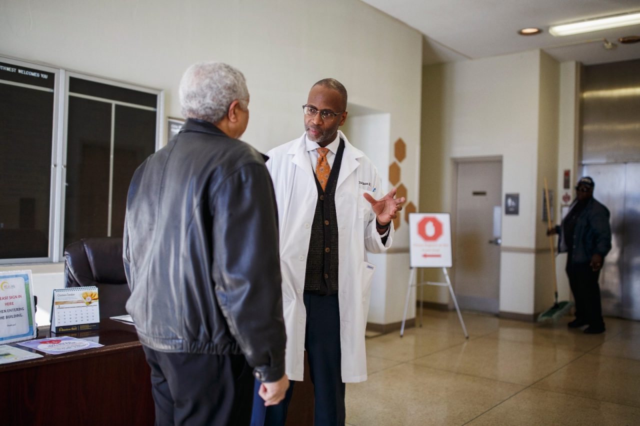 A doctor speaks with a patient at a health clinic.